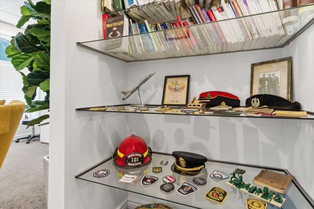 Shelves displaying military, fire and police memorabilia including helmets, badges and books