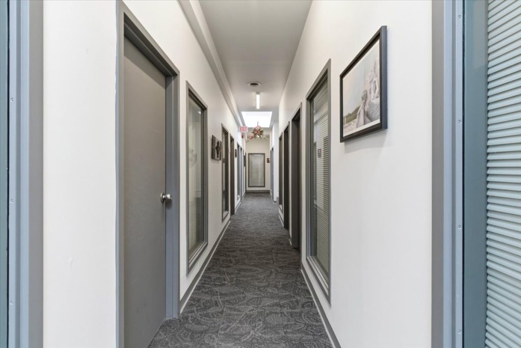 Clinic hallway with office doors and framed artwork