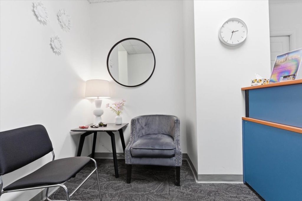 Waiting area with an armchair, side table and blue reception desk