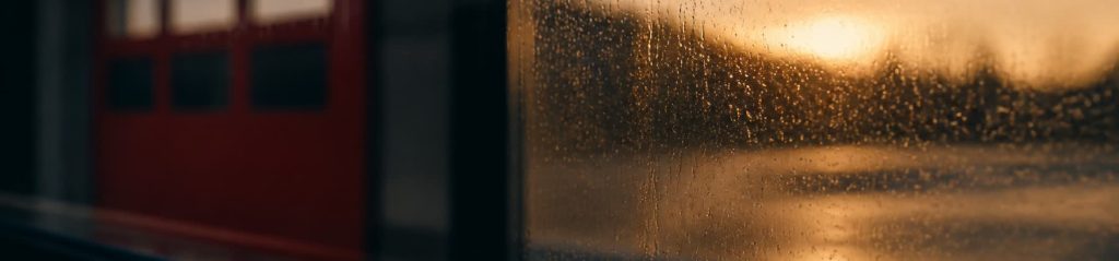 A reflective wide section accent of a fire hall at dawn in the rain.